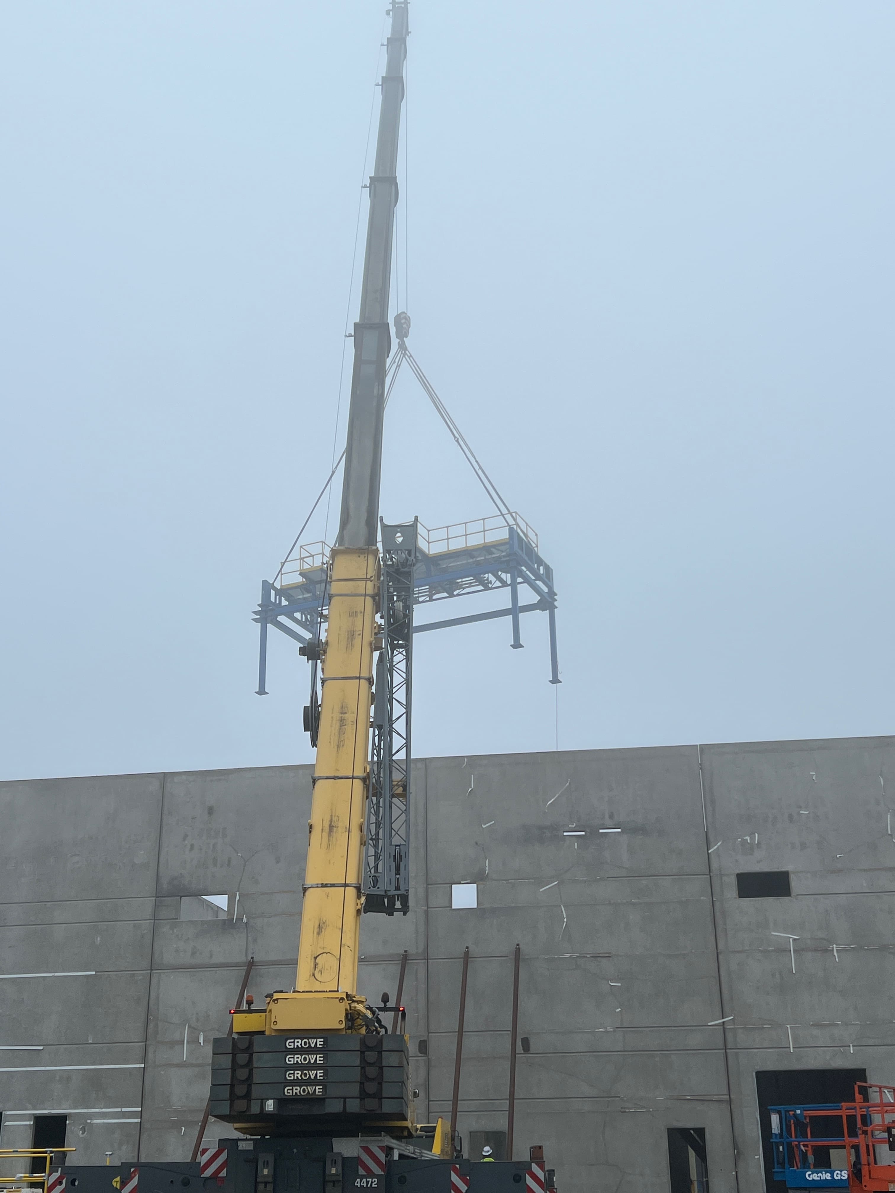Grove mobile crane setting a large steel platform at an industrial building